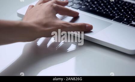 Hand using laptop pc touchpad, personal computer use for work at office or home Stock Photo