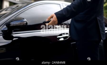 Male in suit pressing remote control of car, alarm system, auto protection Stock Photo