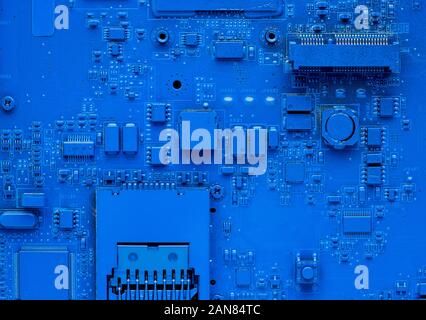 Computer motherboard. Classic blue background with pc backdrop, close up. Single color microchip, top view Stock Photo