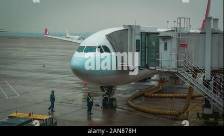 Shanghai, China - January 28, 2019: Airplane ready for boarding in Shanghai airport hub on rainy day Stock Photo