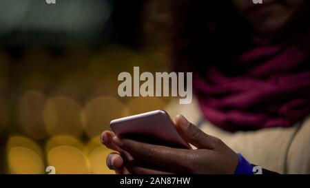 Hands of woman playing in mobile application on her modern gadget, wasting time