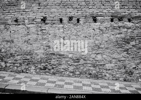 Brick and stone wall near a checkered sidewalk in the streets of Prague (Czech Republic, Europe) Stock Photo