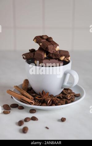 still life, installation, a cup with chocolate, coffee beans, anise and cinnamon sticks on a marble table Stock Photo
