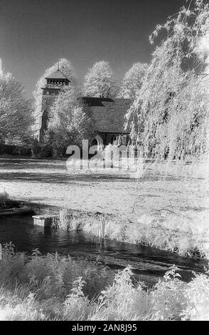 St. Andrews church, Meonstoke, Hampshire, England, UK.  Black and white infra-red filmstock, with its characteristic prominent grain structure, high-contrast and glowing bright foliage. Stock Photo