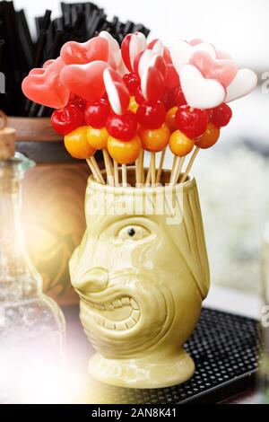 Tiki mug with heart-shaped cocktail decorations, beach drinks Stock Photo