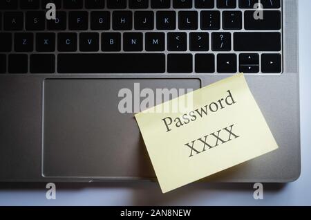 Internet security concept, yellow note paper attach on laptop pad with word "password XXXX" Stock Photo