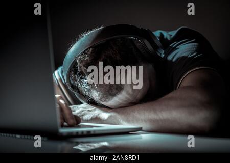 Caucasian Men Sleeping on His Laptop Computer. Hard Working Office Worker Taking Short Sleep Break. Overworked Exhausted Freelancer. Stock Photo