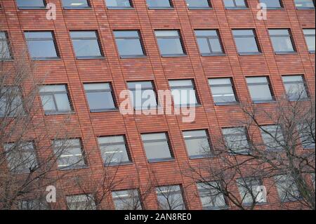 Red brick classic industrial building facade with multiple windows Stock Photo