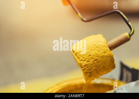 Male students use small paint rollers to paint yellow lines on the cement floor for Sepak Takraw training. Stock Photo