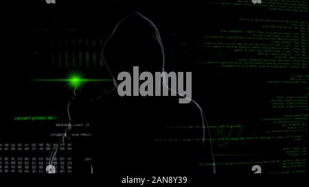 Man in hood push button on virtual screen with scripts, anonymous cyber attack Stock Photo