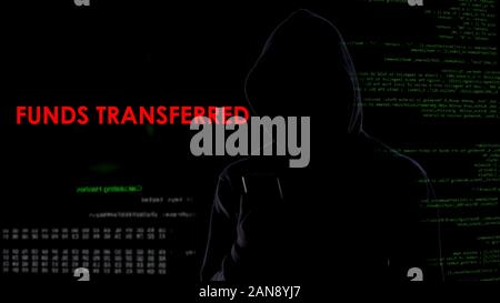 Hacker receiving funds transferred message on screen, bank security attack