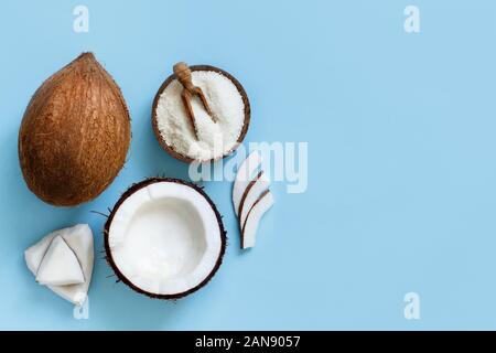 Coconut flour in a bowl with coconut pieces top view on a light blue background Stock Photo