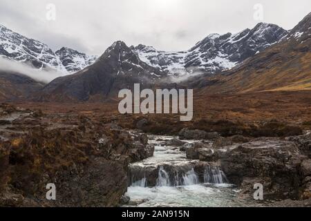 Fairy Pools with mist over the Black Cuillin mountains with waterfalls at the river Brittle, Isle of Skye, Scotland, UK in March Stock Photo
