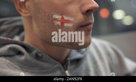 Serious and frustrated football fan watching match, emotions, face closeup Stock Photo