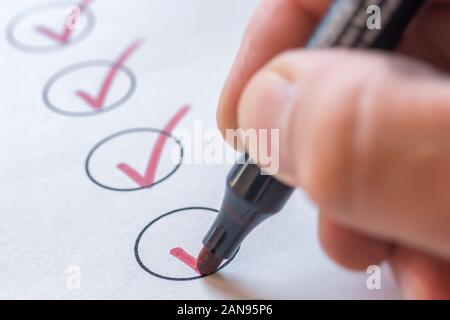 Checking completed tasks on a list Stock Photo