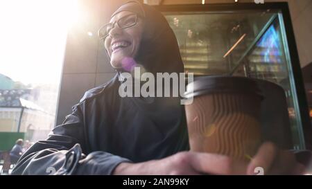 Happy muslim female holding cup of coffee, relaxing in bistro, modern lifestyle Stock Photo
