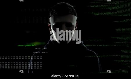 Dangerous man in white mask on codes and numbers background, hacking concept Stock Photo
