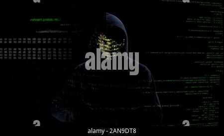 Incognito man looking at codes and numbers on screen, hacker attack, cyber crime Stock Photo
