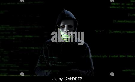 Professional hacker in white mask stealing personal data from pc, threat Stock Photo