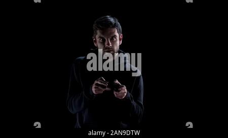 Excited young man playing video games with console, addiction problem, leisure Stock Photo