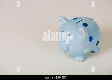 Close up of blue piggy bank isolated over grey background with copy space. Finance and money symbol, savings concept. Stock Photo