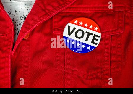 close up of political campaign vote button on red jacket pocket Stock Photo