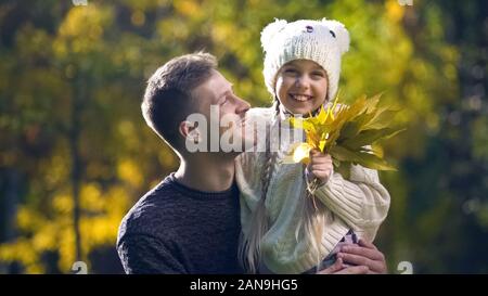 Cheerful father holding cute daughter, strolling in autumn park, fatherhood Stock Photo