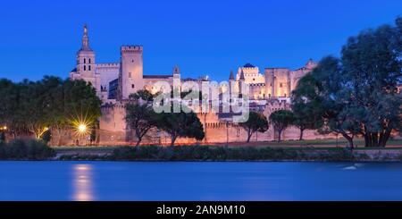 Panoramic view of famous medieval Saint Benezet bridge and Palace of the Popes during evening blue hour, Avignon, southern France Stock Photo