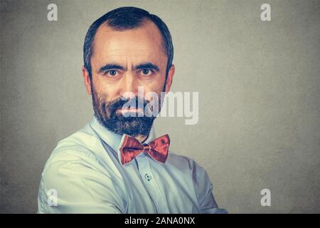 Portrait of a serious young man. Mixed race bearded model isolated on gray studio wall background with copy space. Horizontal image. Stock Photo