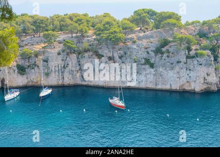 Turquoise sea water, rocky cliffs and boats in Calanques National Park. Stock Photo