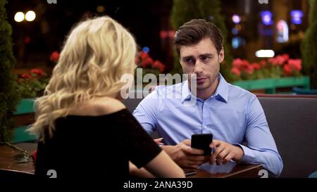 Man looking with annoyance on girlfriend who stopping him surfing net, addiction Stock Photo