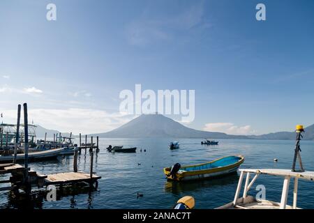 Sunrise at Lake Atitlan Guatemala with boats and docks surrounded by mountains - ducks on the lake Stock Photo