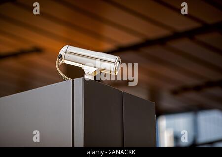 gray camera mounted on a tall cabinet for surveillance and crime protection Stock Photo