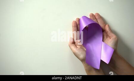 Purple ribbon in lady hands, world Alzheimer disease awareness day, healthcare Stock Photo