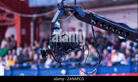 A tv camera on a crane at an indoor stadium broadcasting live. Stock Photo