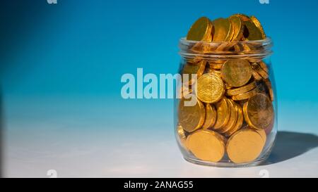 Glass jar full of gold coins Stock Photo