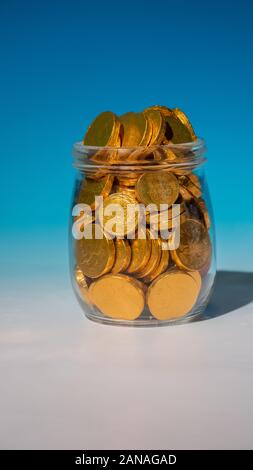 Glass jar full of gold coins Stock Photo