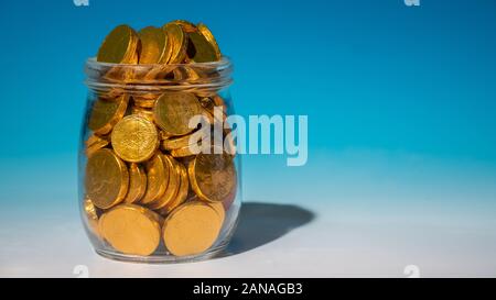 Glass jar full of gold coins Stock Photo