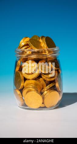 Glass jar full of gold coins Stock Photo