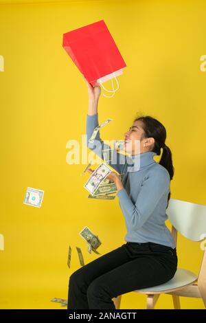 The woman raised the red paper bag and poured out the money into her head. Stock Photo