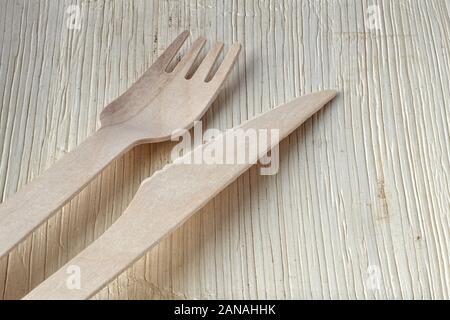 Plastic-free, earth friendly disposable cutlery. Wooden fork and knife on a palm leaf plate, natural product, fully compostable. Go green concept. Stock Photo