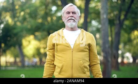Athletic mature man doing morning exercises in park, healthy lifestyle, aging Stock Photo