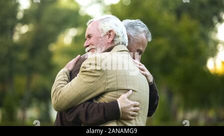 Mature men hugging, happy to see each other, old friends meeting, greeting Stock Photo