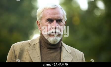 Serious mature man looking into distance, thinking about past, memories, closeup Stock Photo