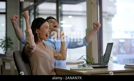 Two excited colleagues showing yes gesture, successful startup, business project Stock Photo