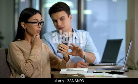 Professional designers discussing core and processor of new smartphone, gadgets Stock Photo
