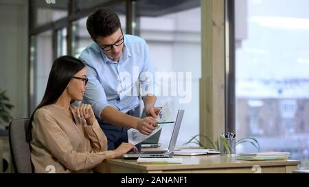 Two company employees preparing report, comparing graphics, business career Stock Photo