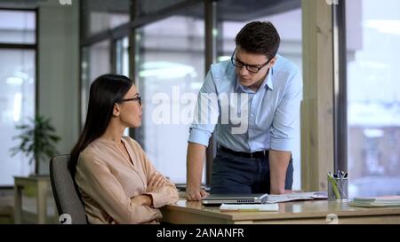 Upset male and female colleagues looking each other, business failure, problem Stock Photo