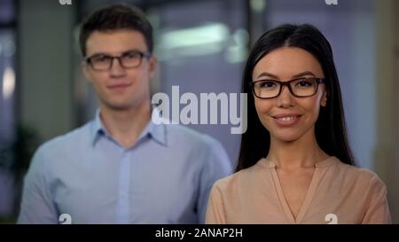 Successful co-workers confidently looking into camera, start-up company team Stock Photo