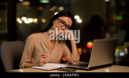 Attractive female student watching educational video on laptop online, internet Stock Photo